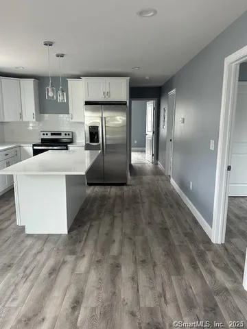 a large kitchen with a refrigerator and a stove top oven