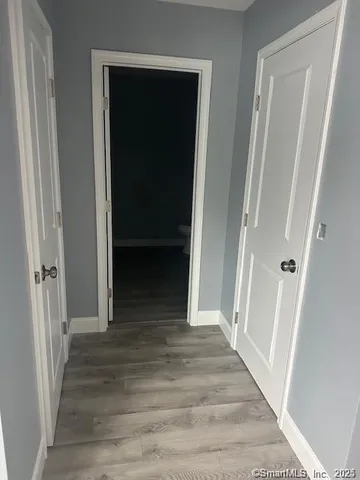 a view of a hallway with wooden floor and staircase