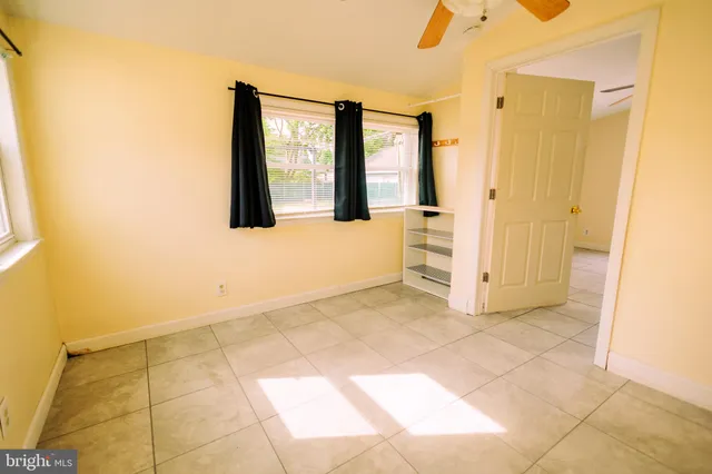 a view of an empty room with window and bathroom