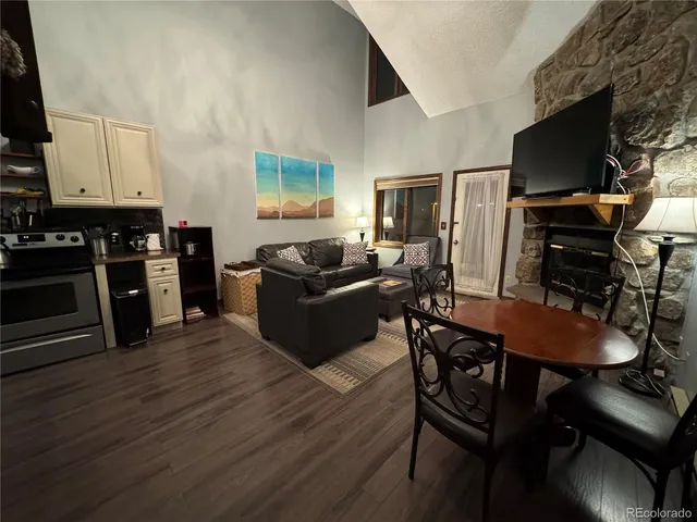 a living room with furniture a flat screen tv and kitchen view