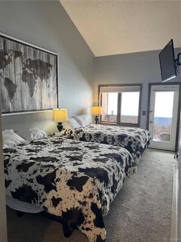 a bedroom with a bed and painting on the wall