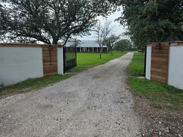 a view of a house with a yard and a large tree