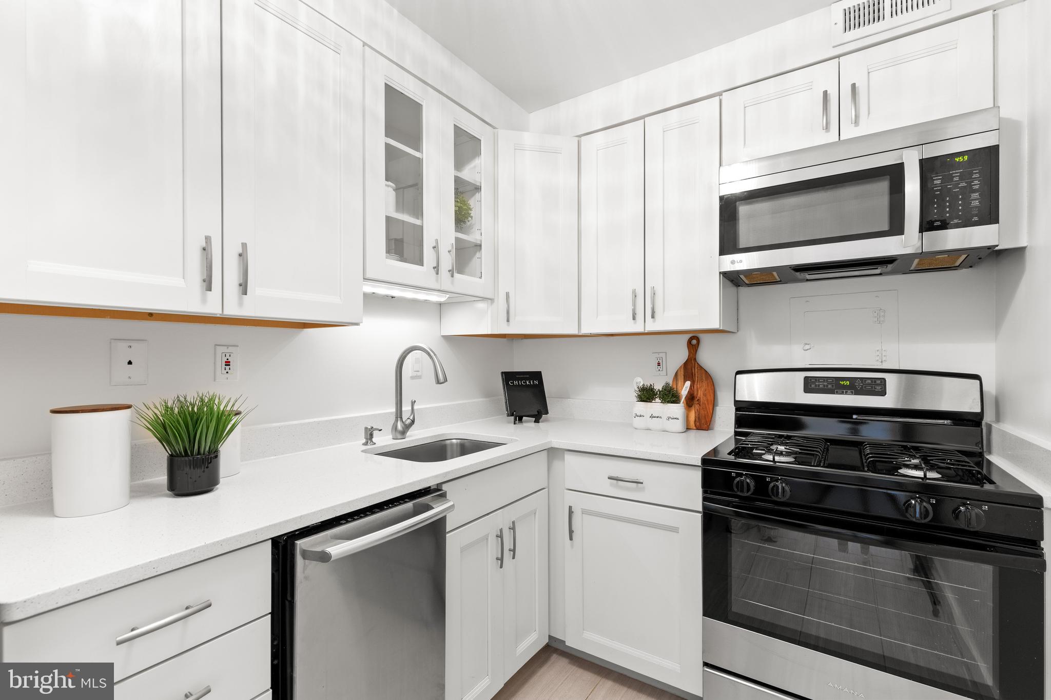300 M Street Southwest, Unit N808 Washington, DC 20024 - Photo 16 of 36 a kitchen with stainless steel appliances white cabinets and a stove top oven