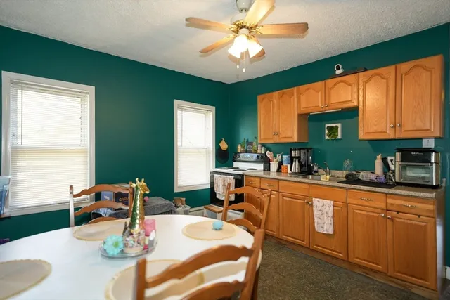 a kitchen with stainless steel appliances wooden floor dining table and chairs