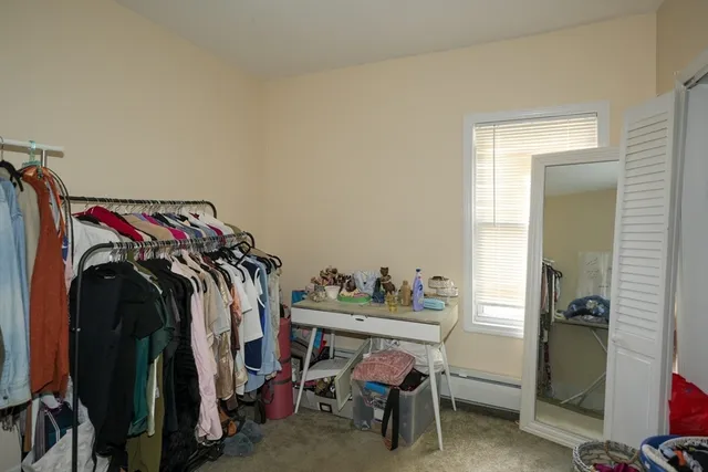 a view of a room that has a bed and a chair in it
