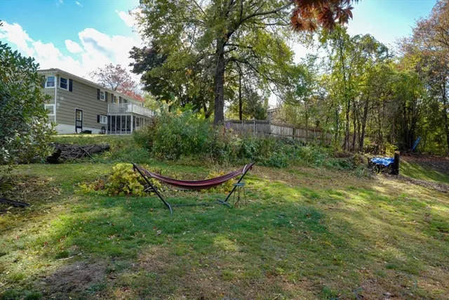 a view of a backyard with table and chairs and potted plants and large trees