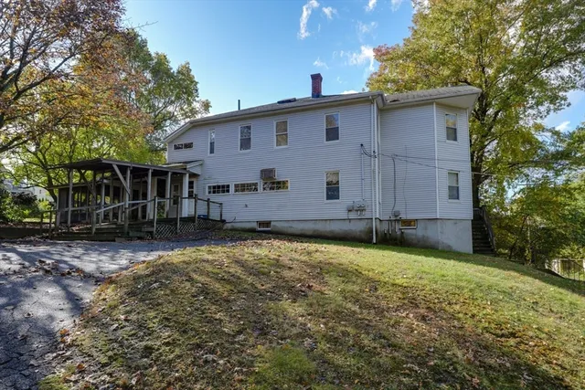 a view of a house with backyard and trees