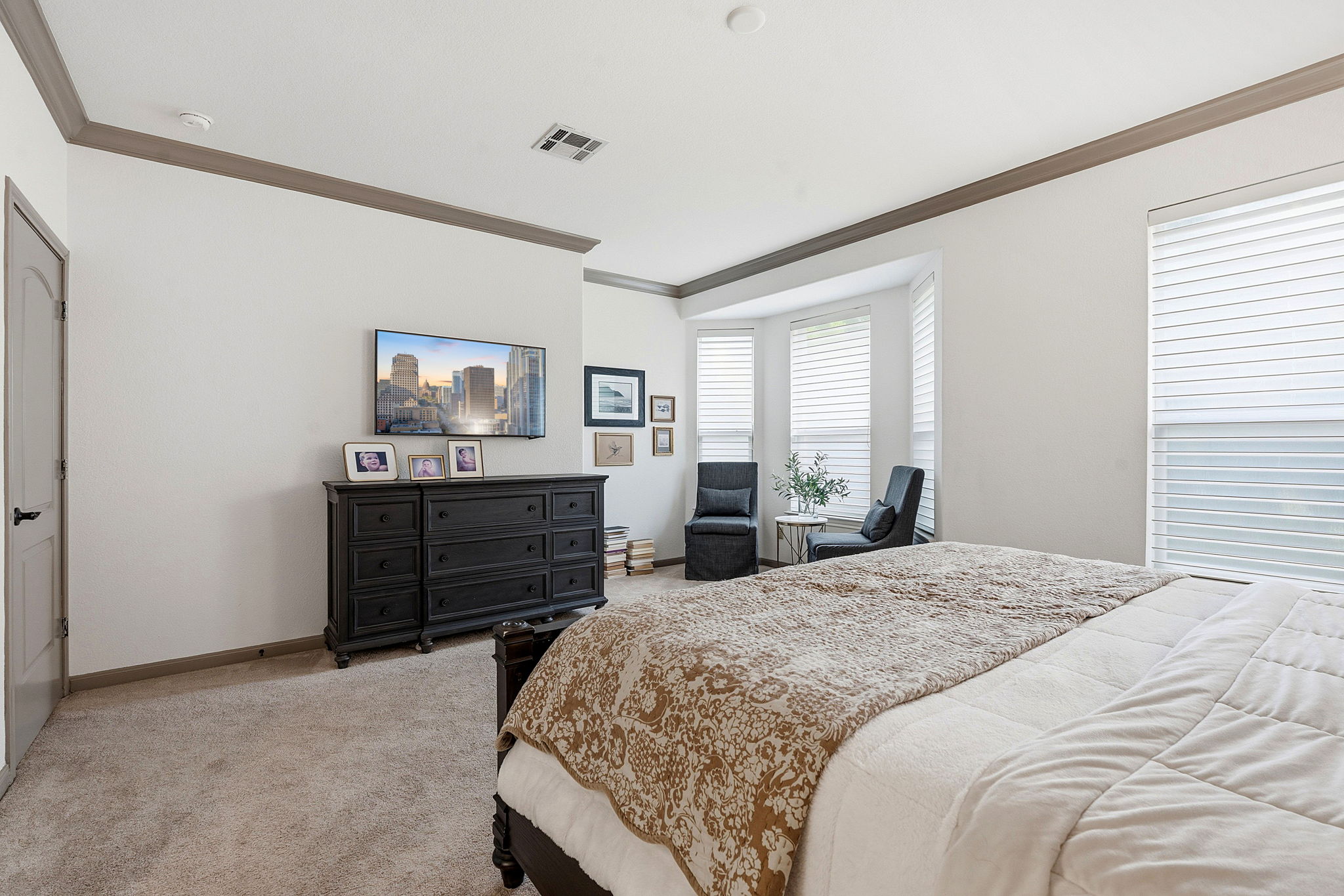 12321 Edenvale Path Austin, TX 78732 - Photo 16 of 36 The primary bedroom offers plush carpeting and ample natural light from it's large windows and extra sitting area.