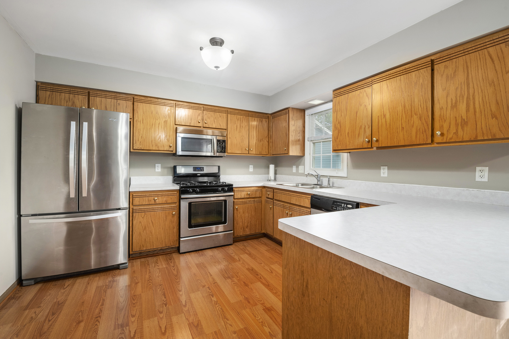 522 Hunters Run Coal City, IL 60416 - Photo 5 of 24 a kitchen with granite countertop wooden floors stainless steel appliances and window