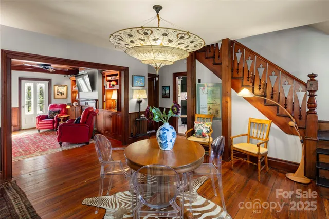a view of a dining room with furniture a chandelier and wooden floor
