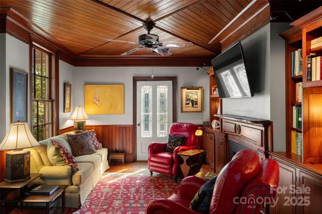 a living room with furniture a flat screen tv and a chandelier