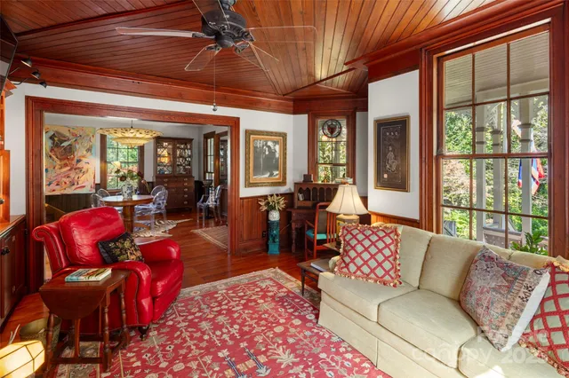 a living room with furniture a fireplace and large windows