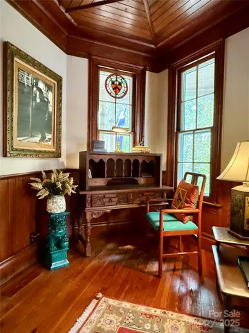 a living room with furniture a fireplace and large windows