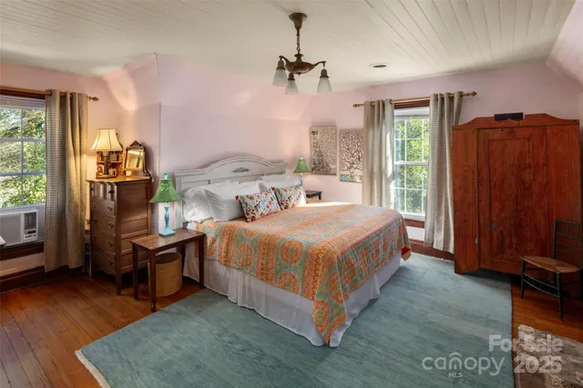 a spacious bedroom with a bed and a dresser