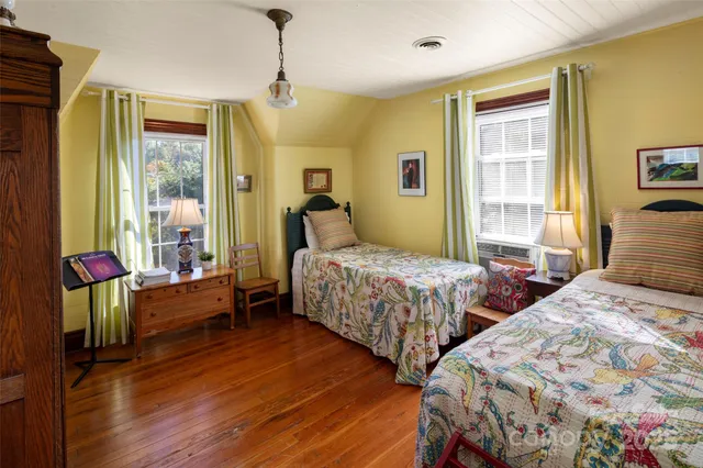 a bedroom with two beds and windows