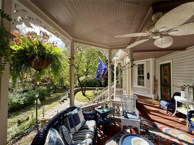 a living room with patio furniture and a potted plant
