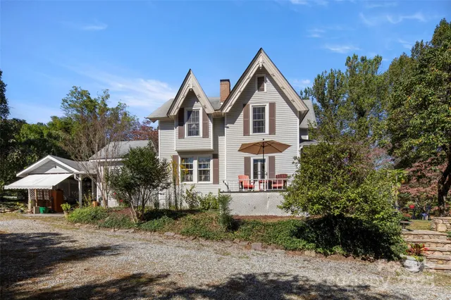 a view of yard in front of house with trees all around