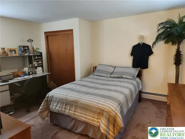 a bedroom with a bed and a potted plant