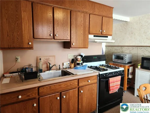 a kitchen with stainless steel appliances granite countertop a stove a sink dishwasher and cabinets with wooden floor
