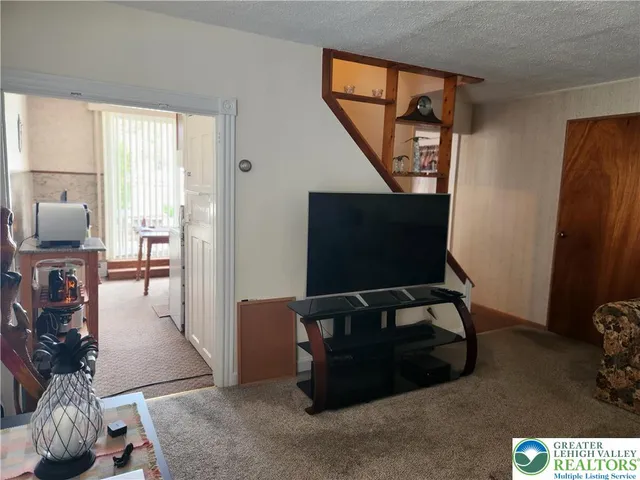 a living room with furniture a flat screen tv and a window
