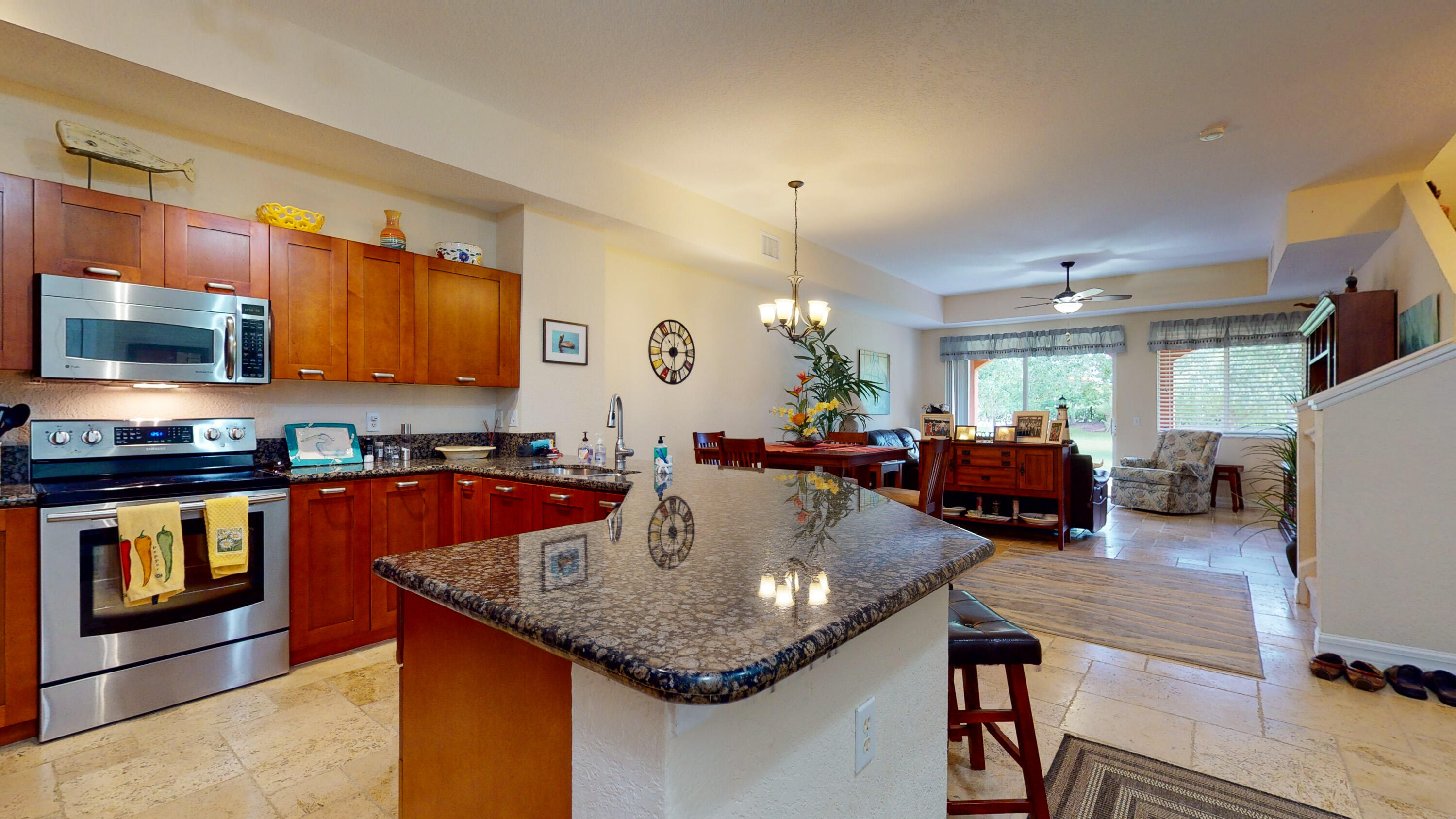 a kitchen with stainless steel appliances granite countertop a granite counter tops and a view of living room