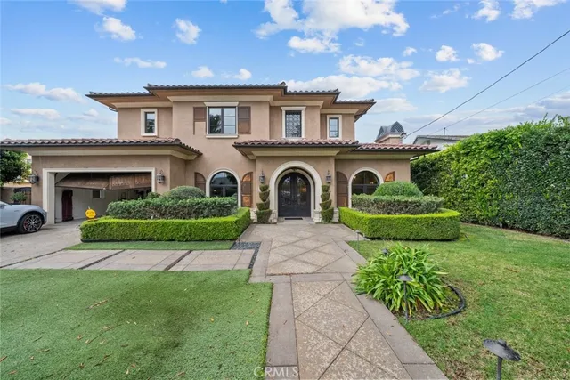 a front view of a house with a garden and plants