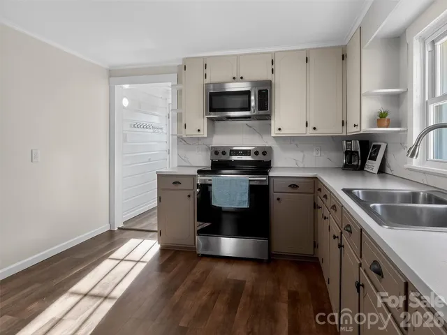 a kitchen with stainless steel appliances granite countertop a stove a sink and a microwave