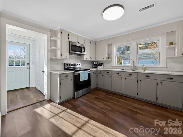 a kitchen with stainless steel appliances granite countertop a stove sink and cabinets