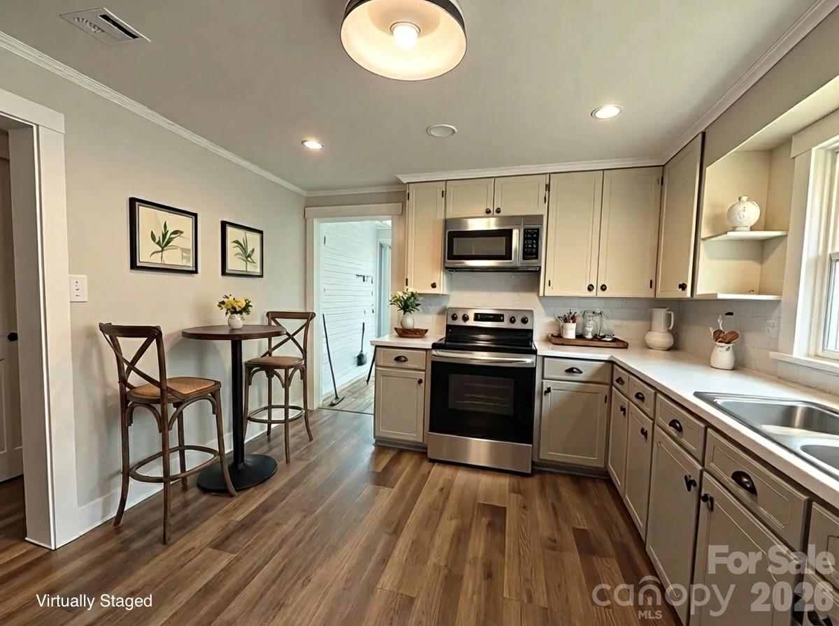 161 Walker Lake Road Forest City, NC 28043 - Photo 8 of 21 a kitchen with kitchen island granite countertop a stove top oven a sink dishwasher a dining table and chairs with wooden floor
