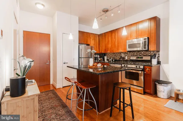 a kitchen with stainless steel appliances granite countertop sink stove and refrigerator