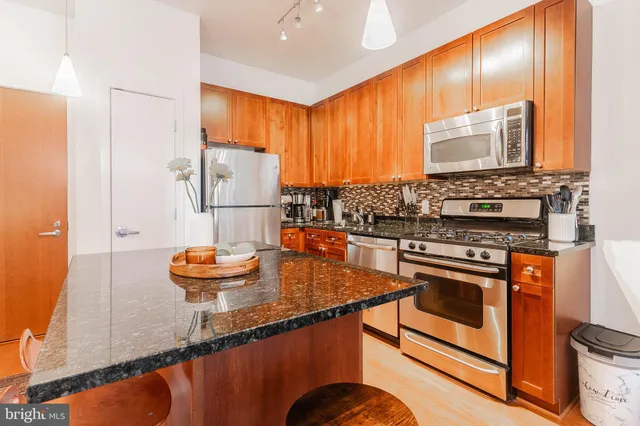 a kitchen with stainless steel appliances granite countertop a sink stove and refrigerator