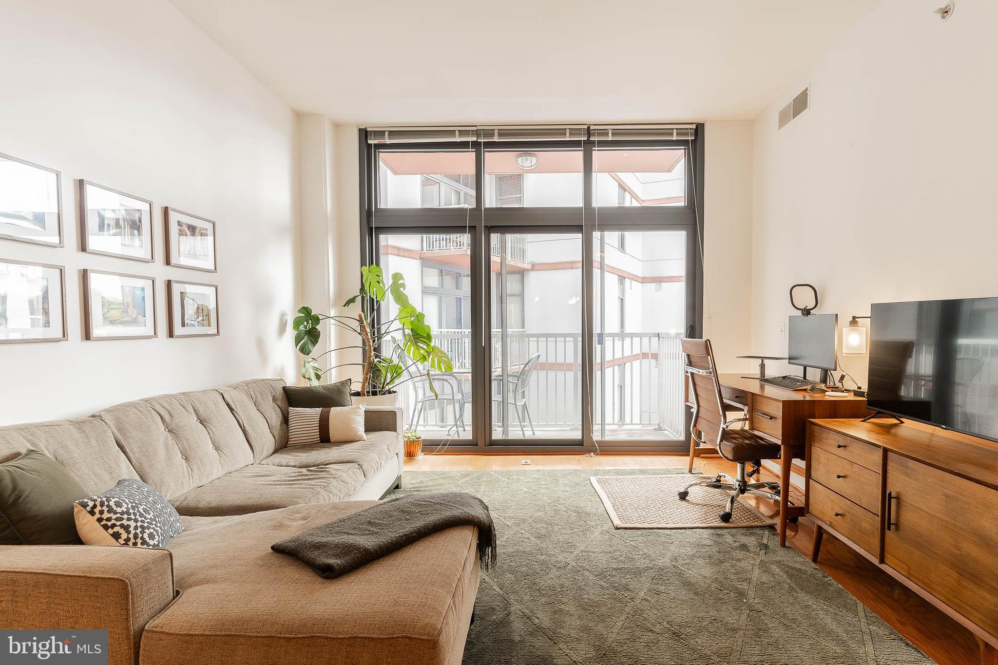 2120 Vermont Avenue Northwest, Unit 312 Washington, DC 20001 - Photo 6 of 16 a living room with furniture and large windows