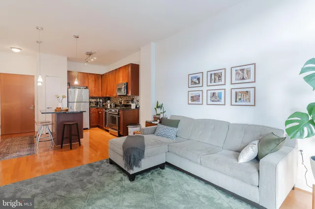 a living room with furniture kitchen view and a large window