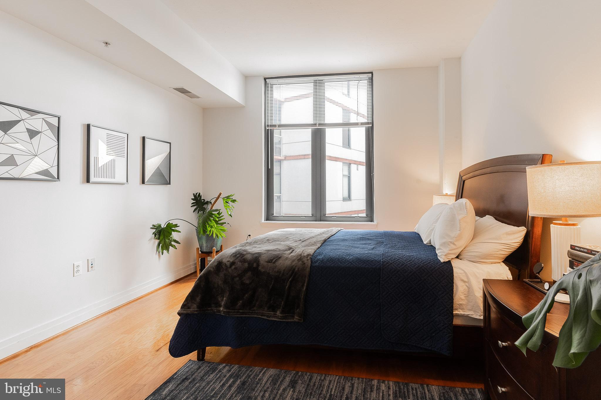 2120 Vermont Avenue Northwest, Unit 312 Washington, DC 20001 - Photo 10 of 16 a bedroom with a bed lamp and a potted plant