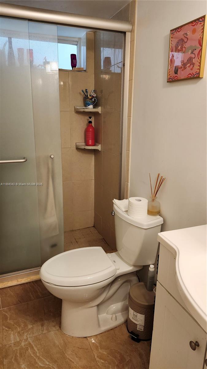 20 Southeast 13th Street, Unit C4 Boca Raton, FL 33432 - Photo 9 of 35 a white toilet sitting next to a bathroom sink and a shower