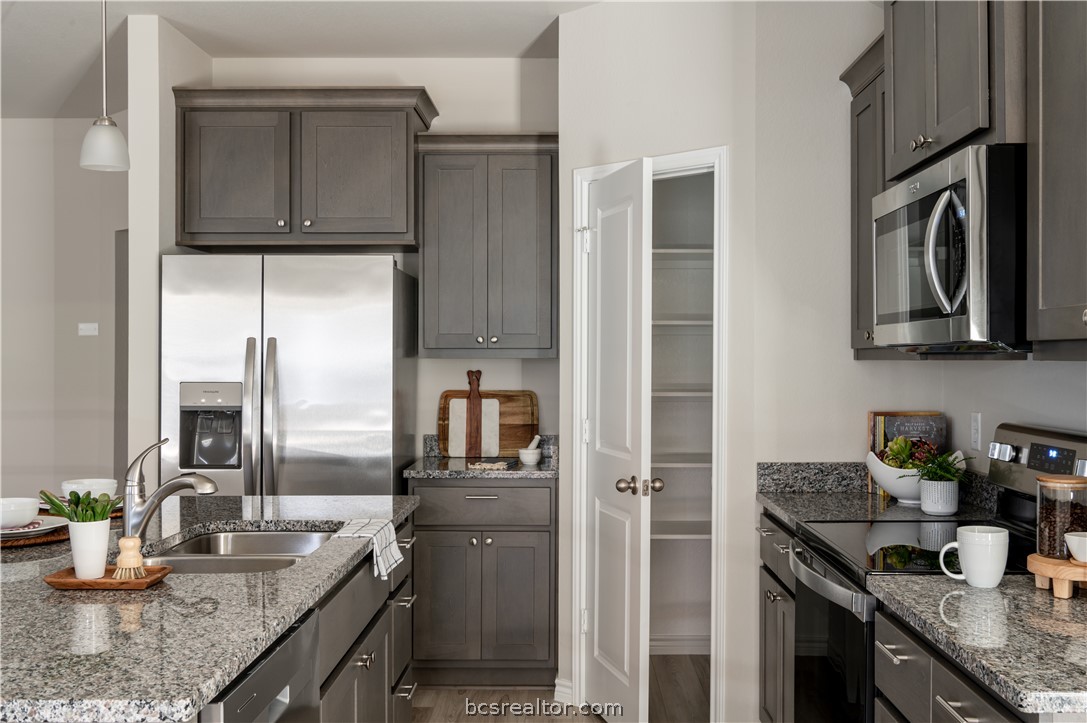 2159 Chief Street Bryan, TX 77807 - Photo 7 of 22 a kitchen with granite countertop a sink stove and refrigerator