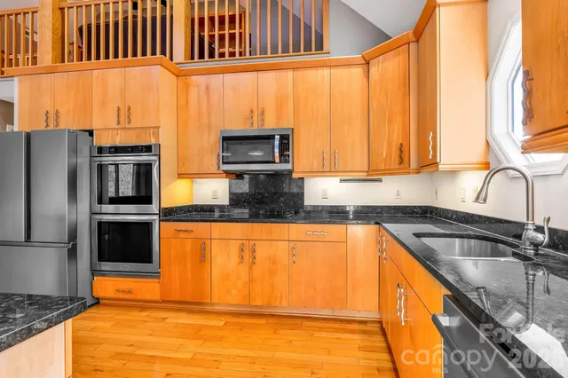 a kitchen with sink a microwave and cabinets
