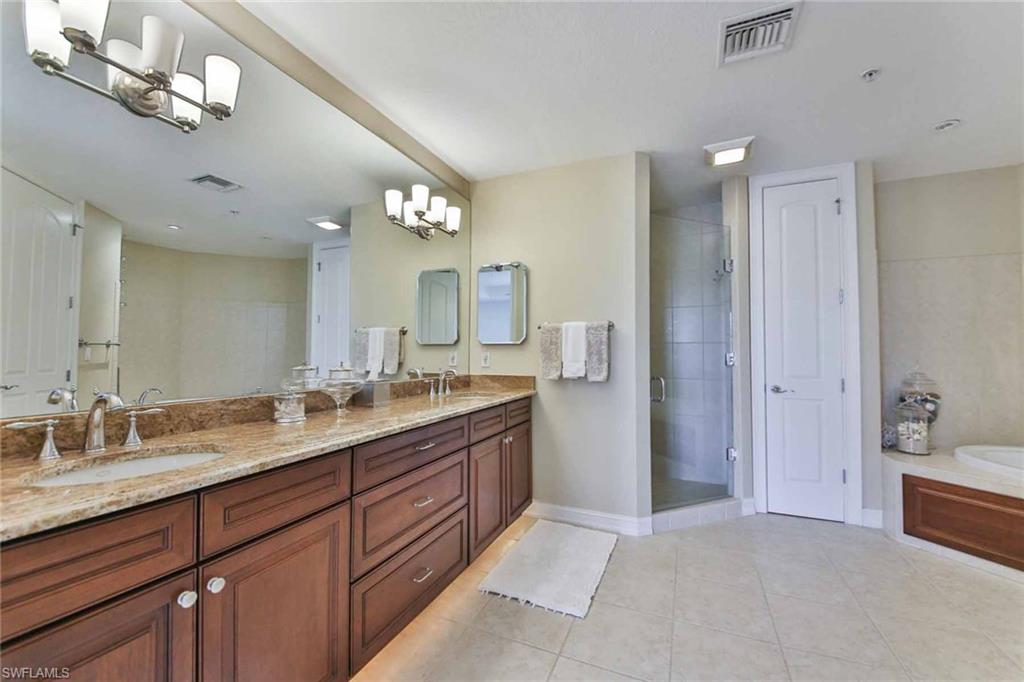 600 5th Avenue South, Unit A212 Naples, FL 34102 - Photo 14 of 21 a spacious bathroom with a granite countertop sink a mirror and a shower