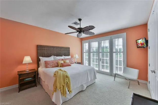 a bedroom with a bed and a large window