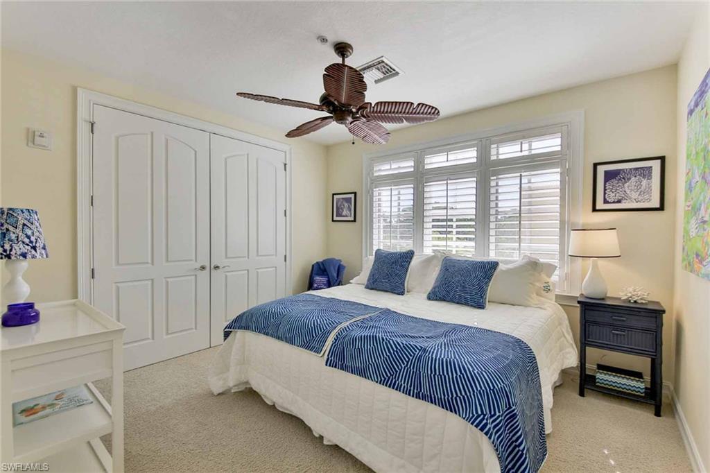 600 5th Avenue South, Unit A212 Naples, FL 34102 - Photo 18 of 21 a bedroom with a bed and a chandelier