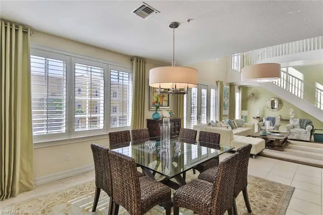 a dining room with furniture a chandelier and wooden floor