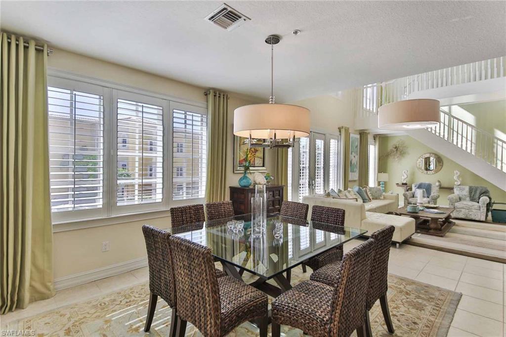 600 5th Avenue South, Unit A212 Naples, FL 34102 - Photo 3 of 21 a dining room with furniture a chandelier and wooden floor