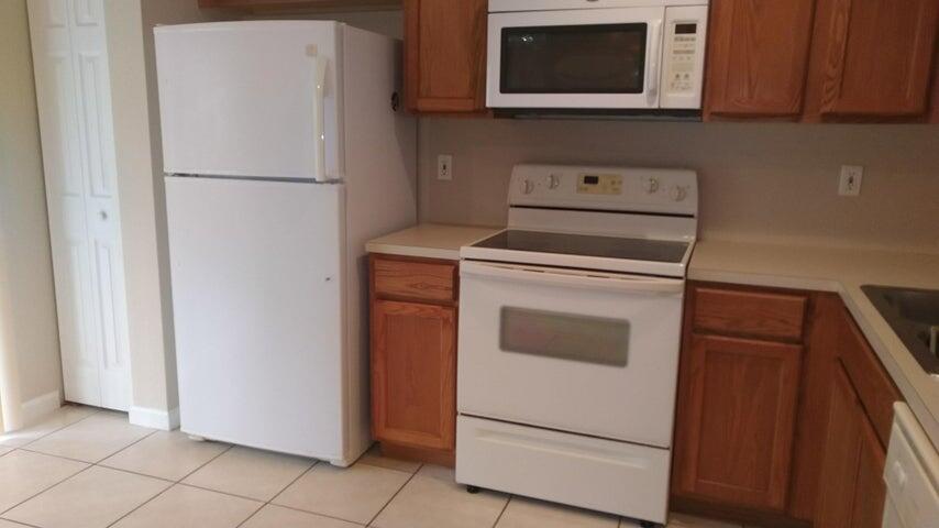 8052 Big Pine Way Riviera Beach, FL 33407 - Photo 3 of 10 a white refrigerator freezer sitting inside of a kitchen