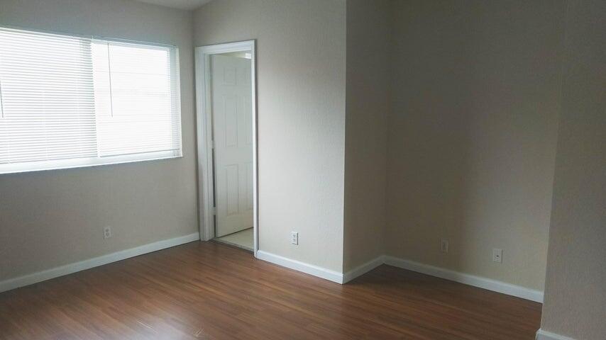 8052 Big Pine Way Riviera Beach, FL 33407 - Photo 4 of 10 an empty room with wooden floor and windows