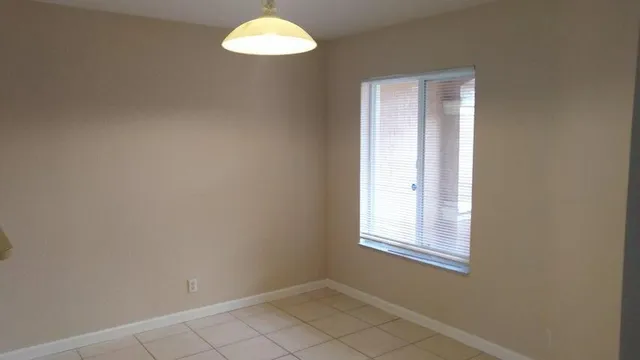 an empty room with windows and mirror