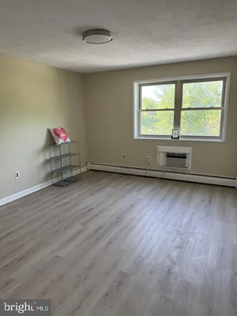 an empty room with windows and ceiling fan