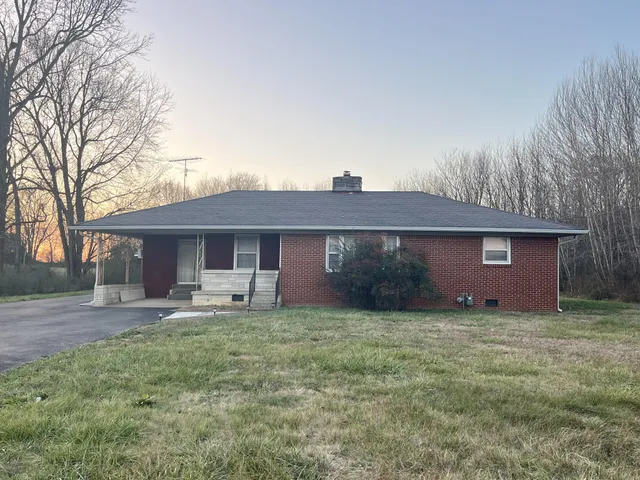 a front view of a house with yard and trees