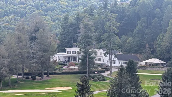a aerial view of a residential apartment building with a yard and large trees