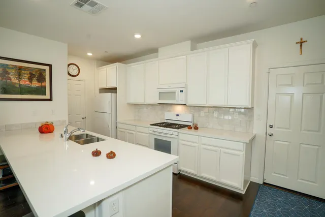 a kitchen that has a sink a stove and cabinets