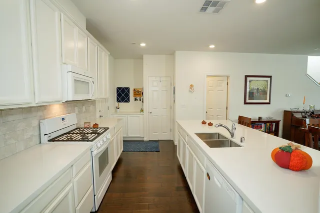 a kitchen that has a sink a stove and cabinets